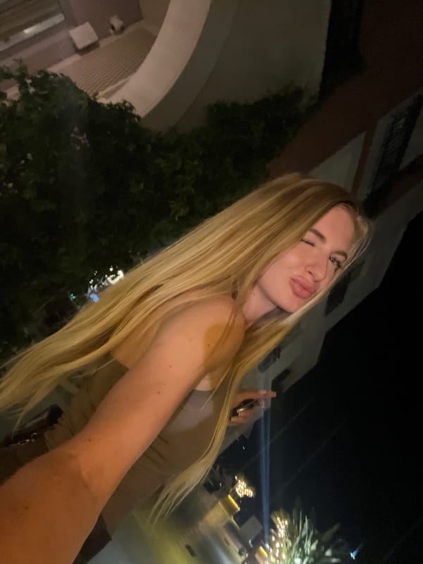 Woman makes playful expressions outdoors in Tivat at night