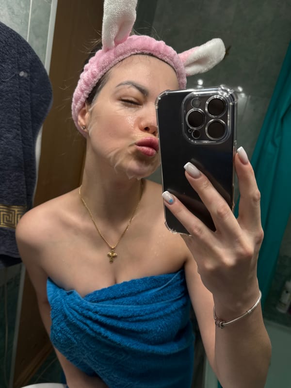Person takes bathroom selfie wearing bunny ears and face mask