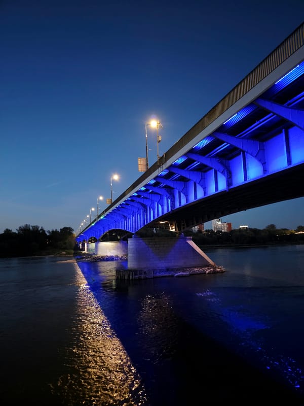 Poniatowski Bridge glowing blue at dusk over the Vistula