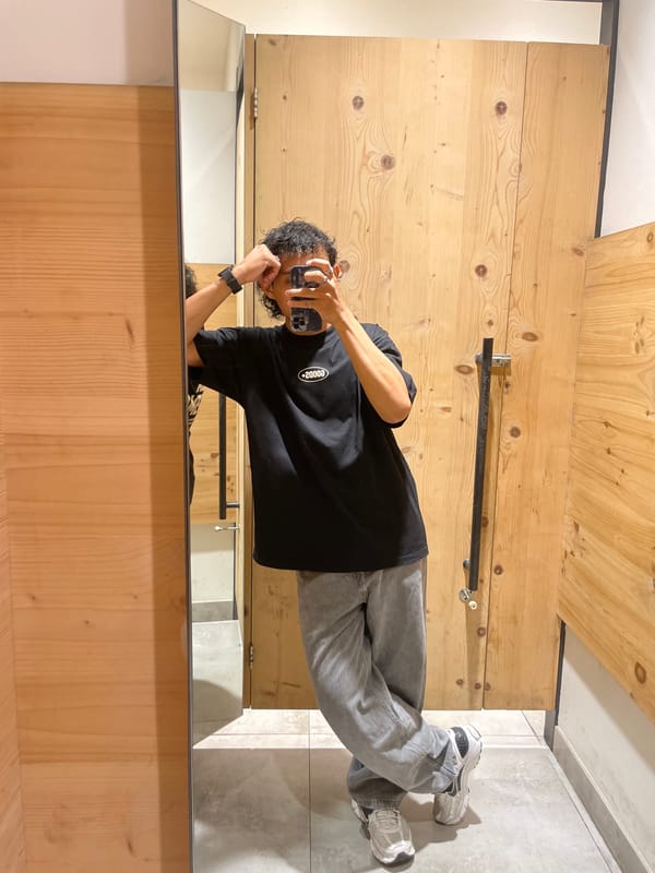 Fitting room mirror selfies trying on a retro logo tee