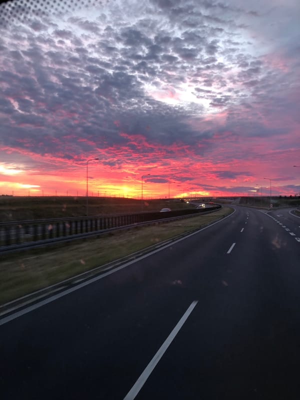 Vivid sunset over a Polish highway, early evening.