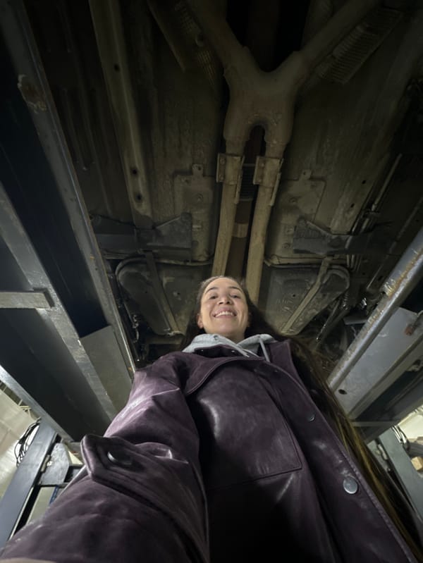 Woman documents car repair work at Russian auto shop