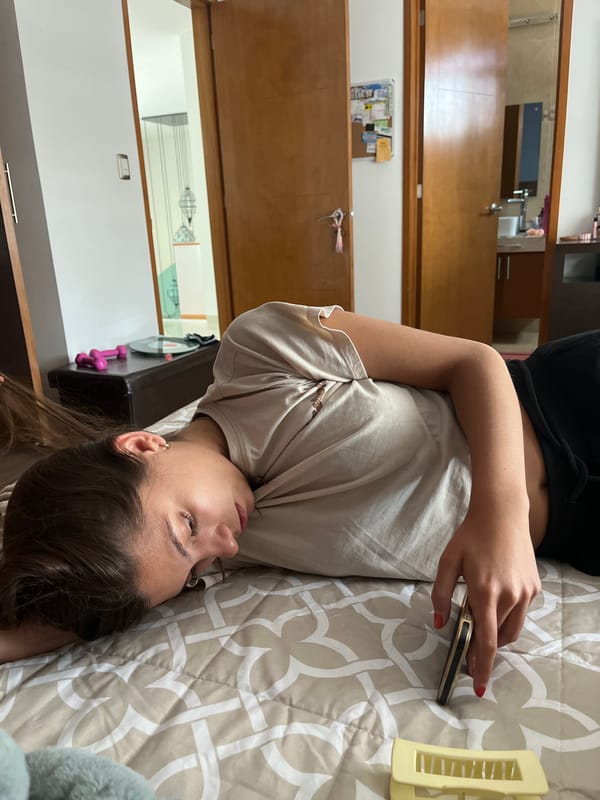 Woman uses smartphone while resting on bed in Mexico