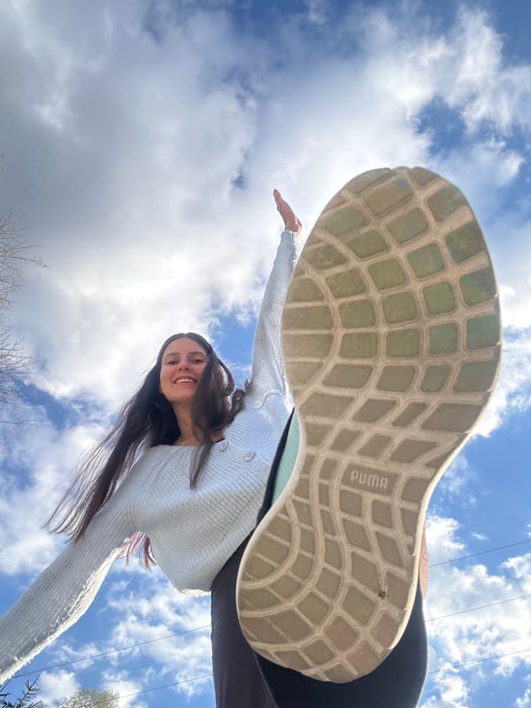 Woman photographed with extended arm beneath Puma shoe in Wisła
