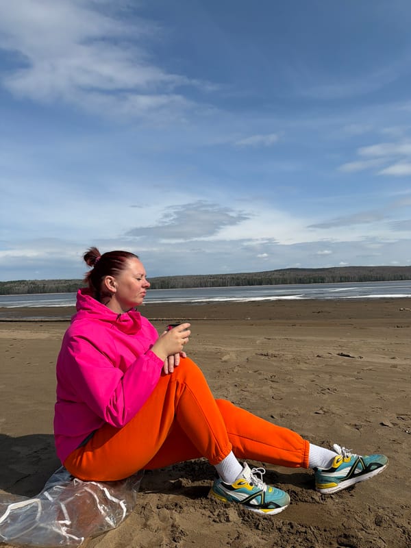 Woman enjoys sunny morning at Chaikovsky beach amid forest landscape