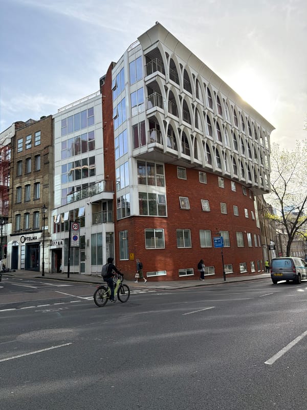 Colorful London taxi spotted parked near mixed architecture building