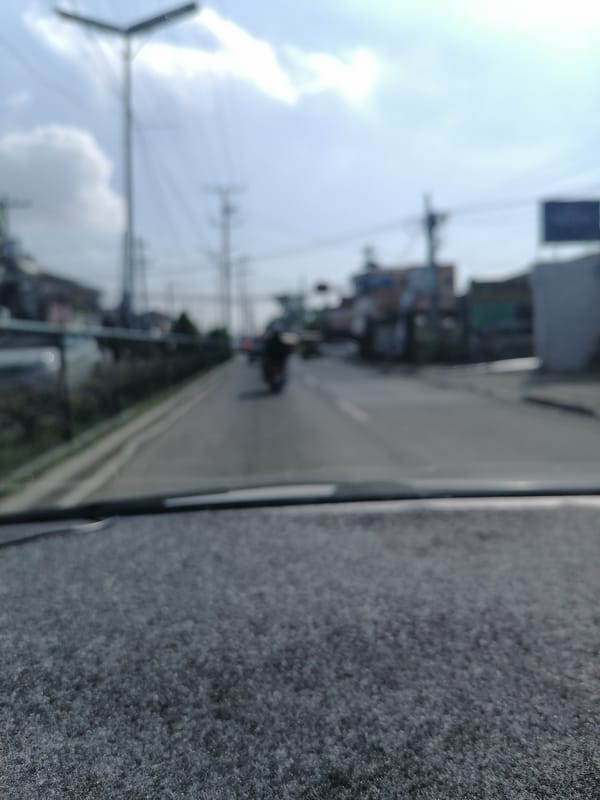 Blurred street view captured from vehicle in Davao City