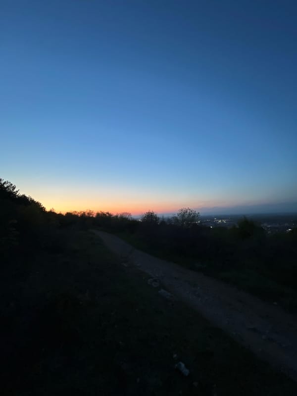 Evening walker captured on hillside path overlooking Asenovgrad