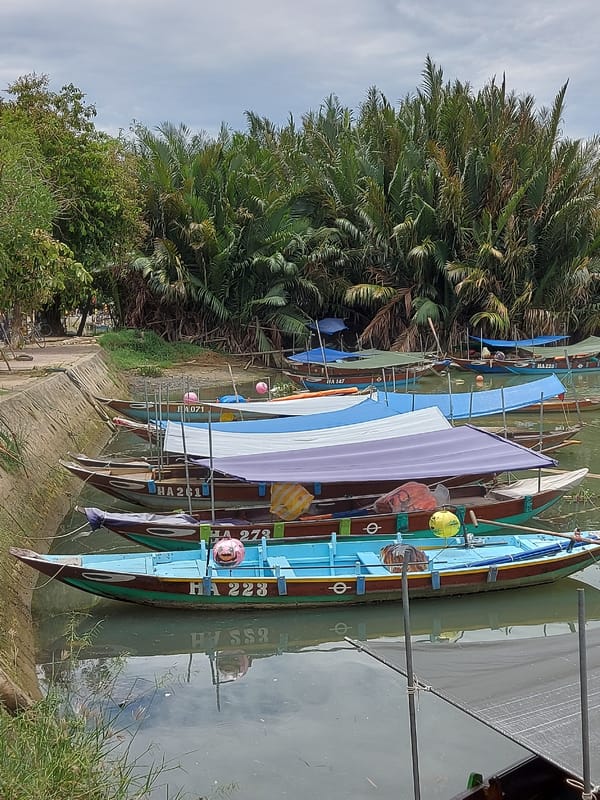 Hoi An's covered bridge and canal boats on a quiet morning