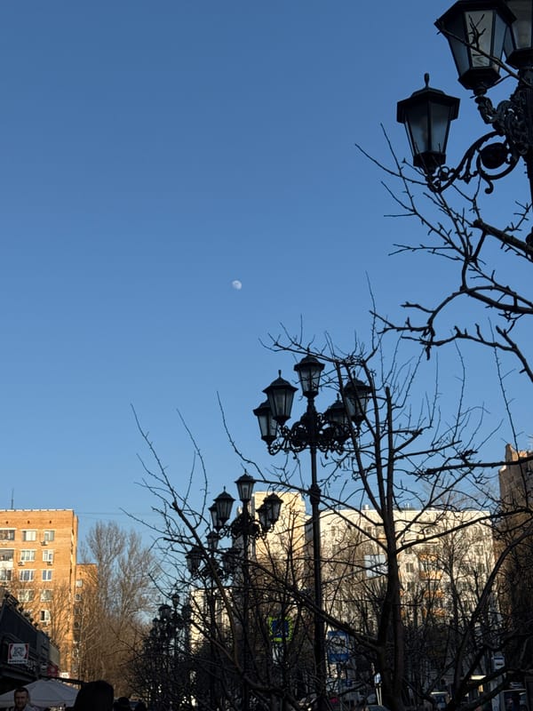 Daytime crescent moon visible over Moscow street scene