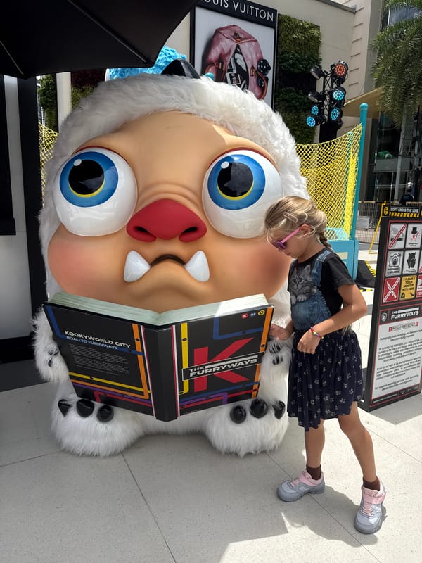 Posing with giant monster mascots at a Bangkok attraction