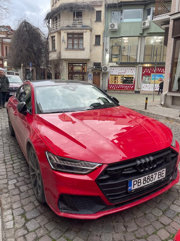 Red Audi parked on cobblestone street in Plovdiv