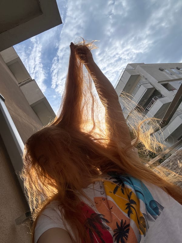 Woman takes selfies on Montenegro balcony during golden hour