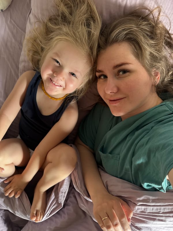 Mother and child share quiet morning moment on bed