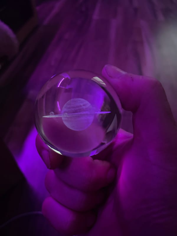Saturn-etched glass orb under purple light, Gliwice