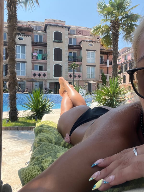 Poolside lounging in a black bikini, sun on feet