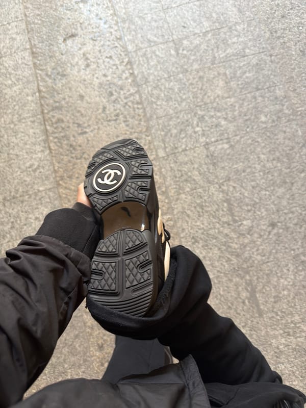 Person displays Chanel sneaker sole on Milan pavement
