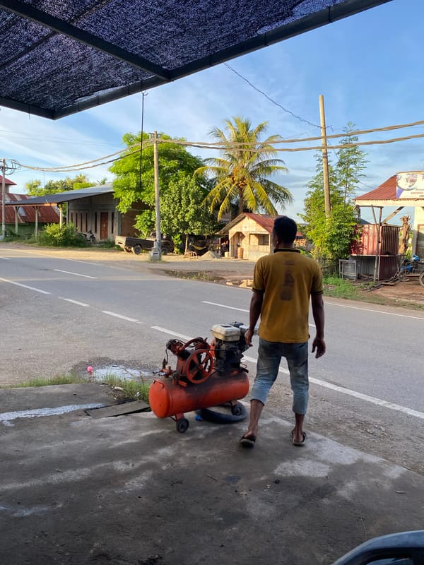 Informal roadside auto repair shop with tools and equipment