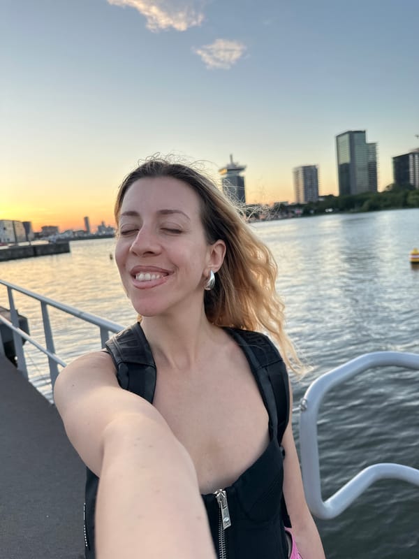 Amsterdam waterfront at golden hour, barges and people soaking it in