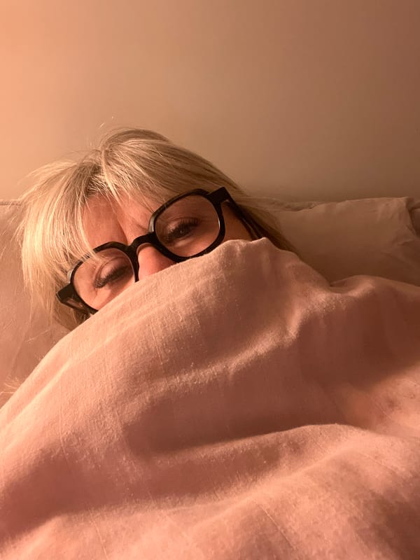 Person peers from pink blanket indoors in Chambœuf