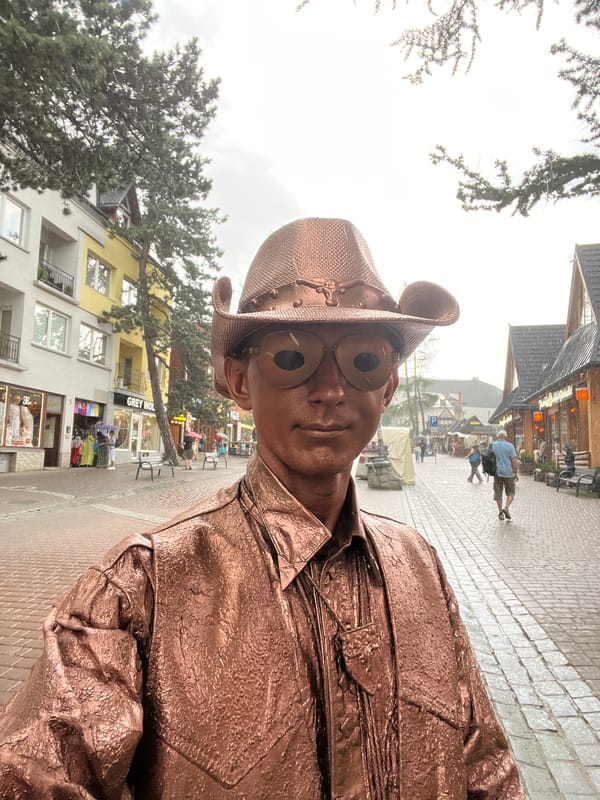Bronze cowboy street performer works Zakopane's rainy cobblestones