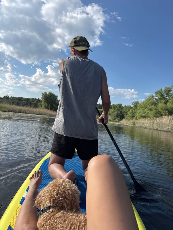 Paddleboarders with dog enjoy afternoon outing near Pribrezhnyi