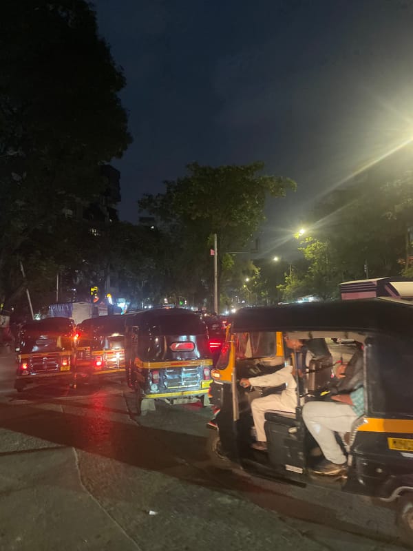 Mumbai night street: traffic, flower stalls, and a garlanded shrine