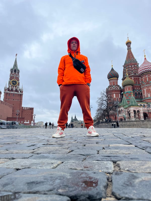 Tourist in orange outfit poses at Moscow's Red Square