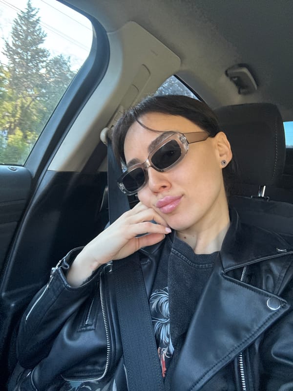 Woman in sunglasses sits in car in Tbilisi
