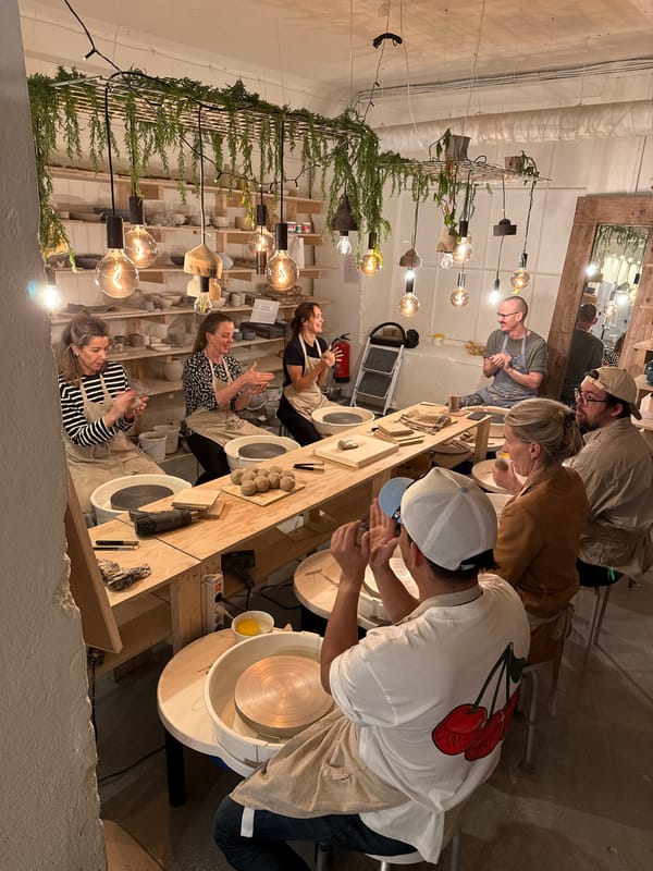 Pottery workshop in session with multiple participants crafting ceramics