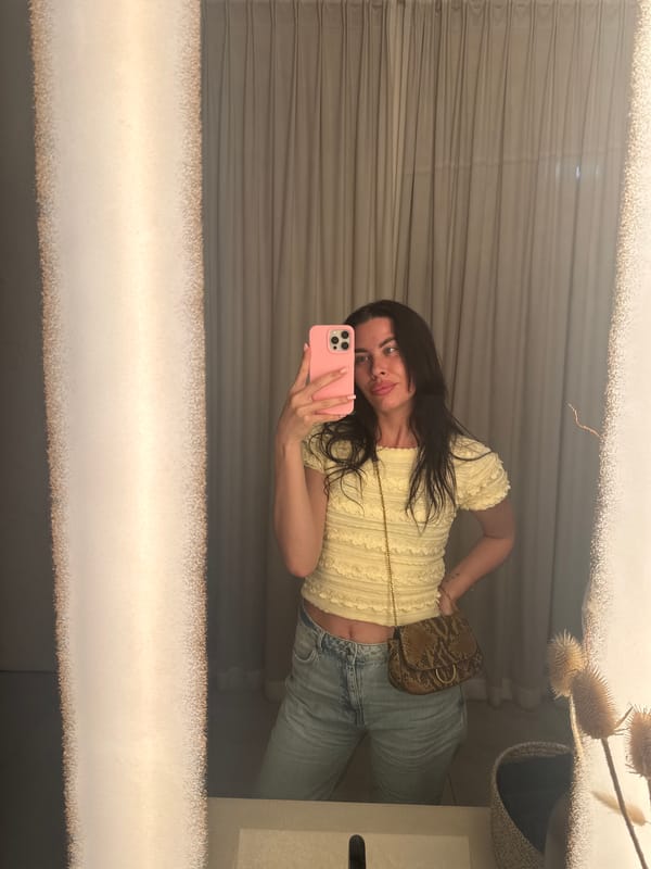 Mirror selfie in Perm hallway, yellow top and snake-print bag