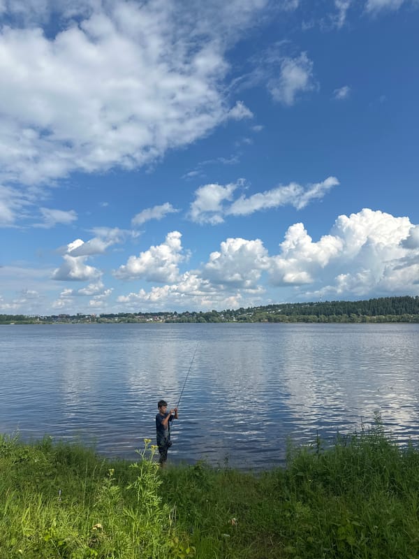 Fishing in the Volga shallows, forested hills across the river