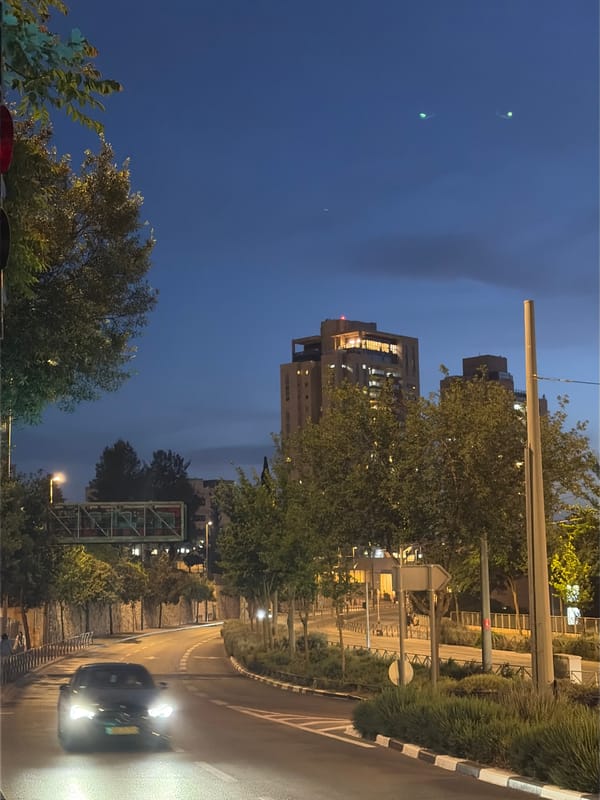 Evening traffic flows through Jerusalem streets amid wet conditions
