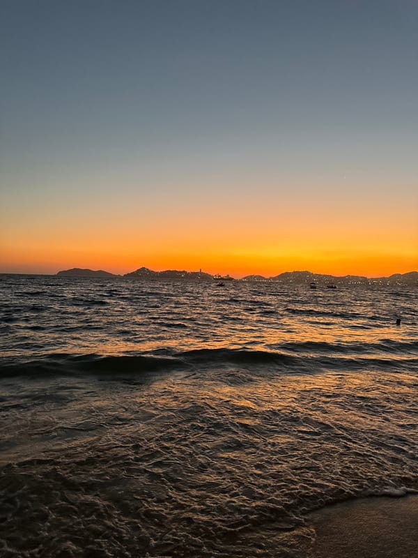 Sunset observed over Acapulco coastline with orange skies