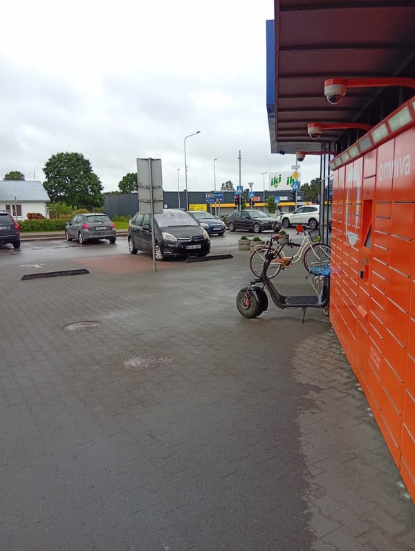 Everyday errands around Kuršėnai's commercial strip on a cloudy morning