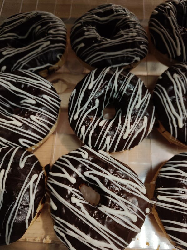 Decorated donuts displayed in case observed by witness