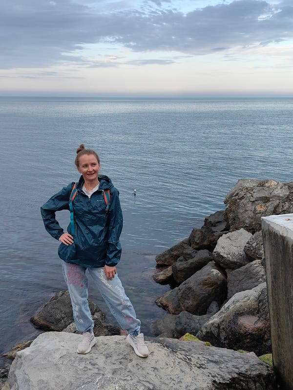 Woman poses on rocky coastline in Utios, Ukraine