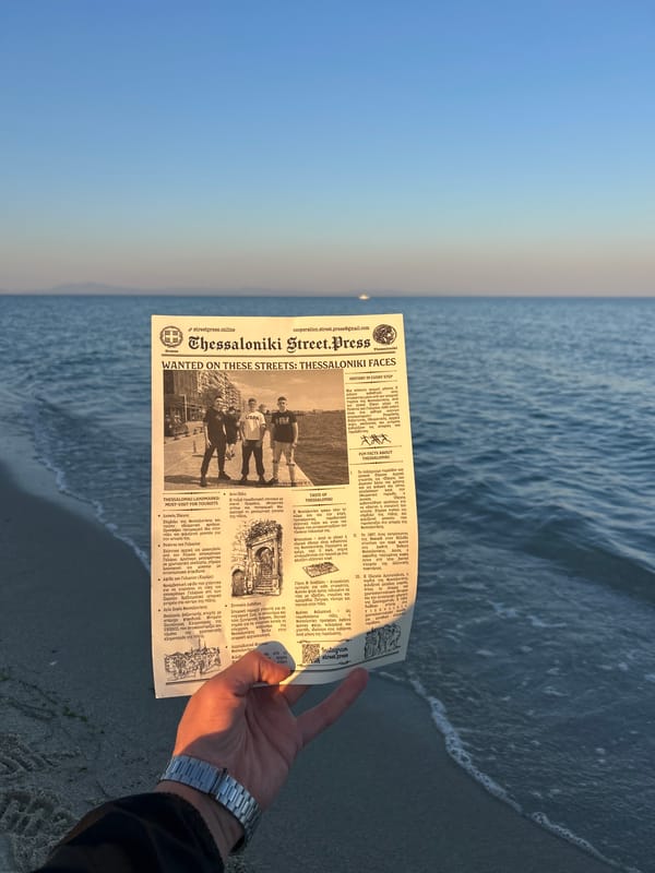 Person reads newspaper at Greek beach during evening hours