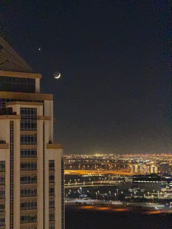 Doha skyline at night, from waterfront Ferris wheel to crescent moon