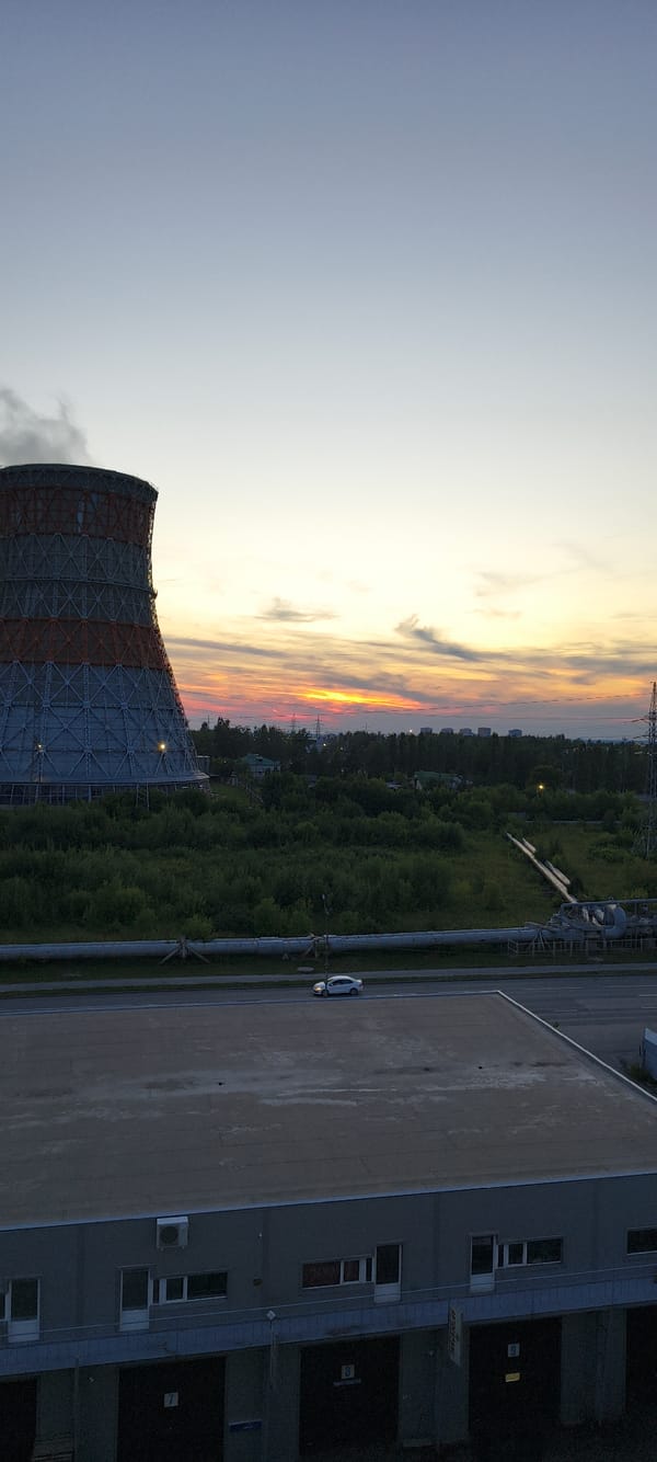 Industrial city at golden hour, street life and cooling towers