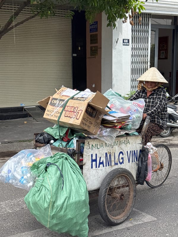 Recycling tricycles and street traffic on a Nha Trang block