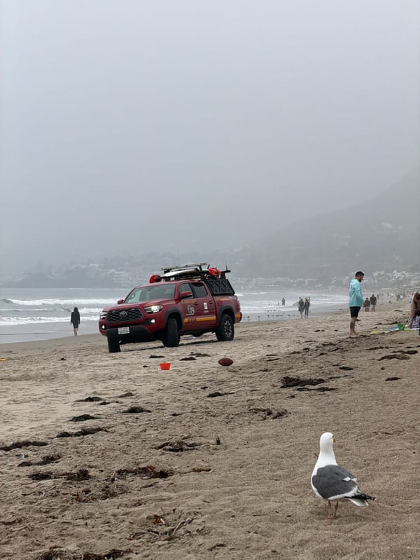 Evening beach activities continue under overcast skies in Malibu
