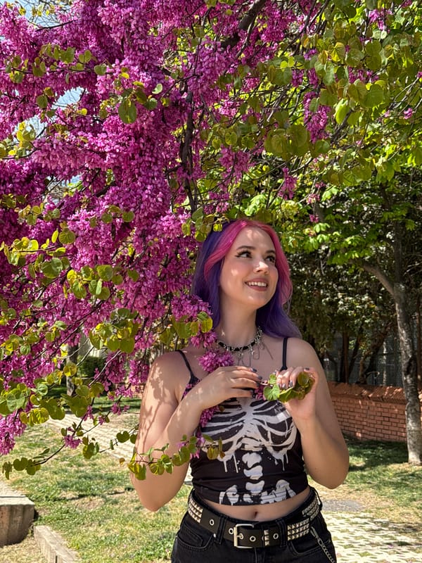 Woman poses among blooming wisteria in Madrid park