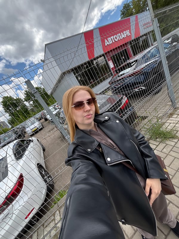 Woman sits on bench near autograph fence in Yaroslavl