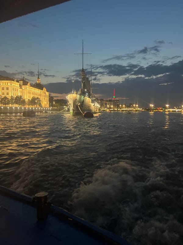 Evening cruise past the Aurora and Saint Petersburg's lit waterfront