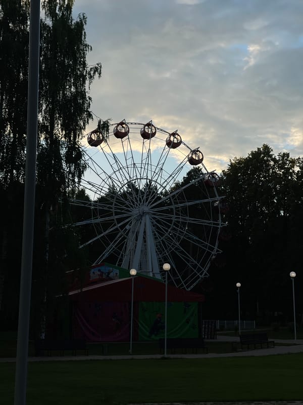 Fairground rides, street food, and carnival stalls on a cloudy afternoon.