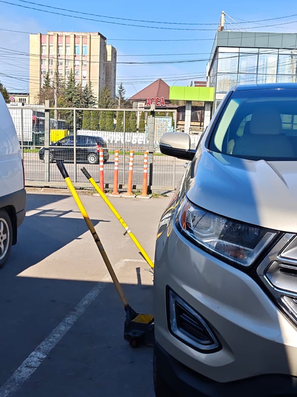 Driver changes tire in Vinnytsia parking lot early morning