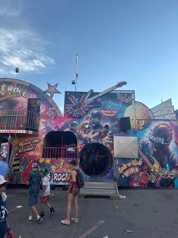 Calgary carnival: rides, game booths, and a teal Ferris wheel