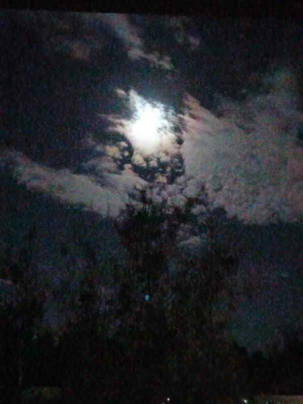 Bright moon observed through clouds in Belarus night sky