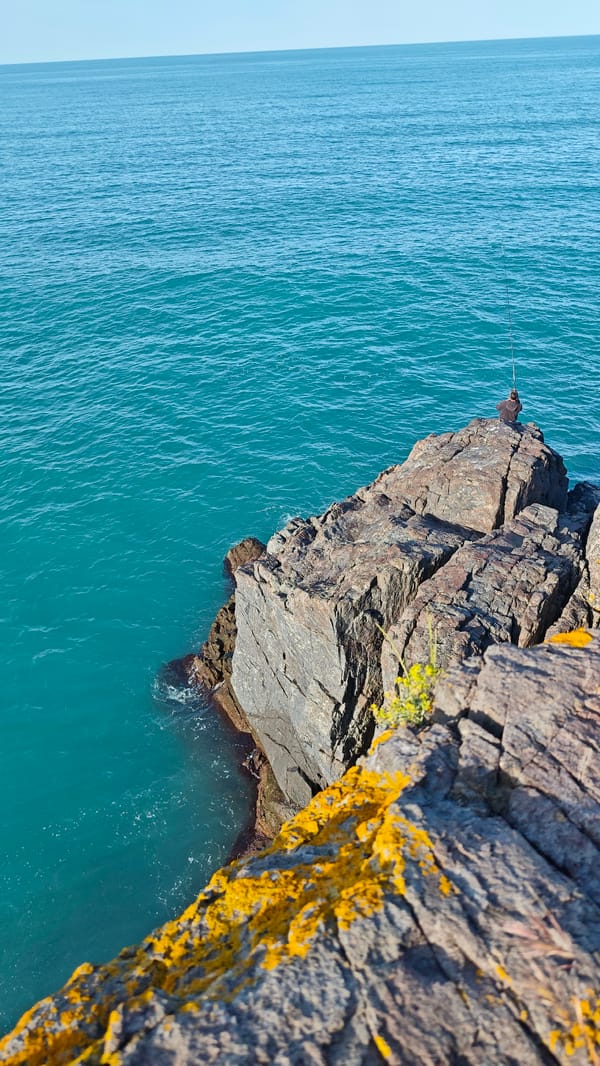 Angler fishes from rocky cliff on Bulgarian Black Sea coast